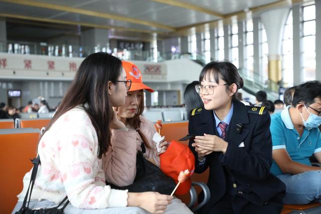 图为3月17日,红河站客运副站长张跃馨通过智能翻译机与越南旅客对话。(刘昊亮 摄)