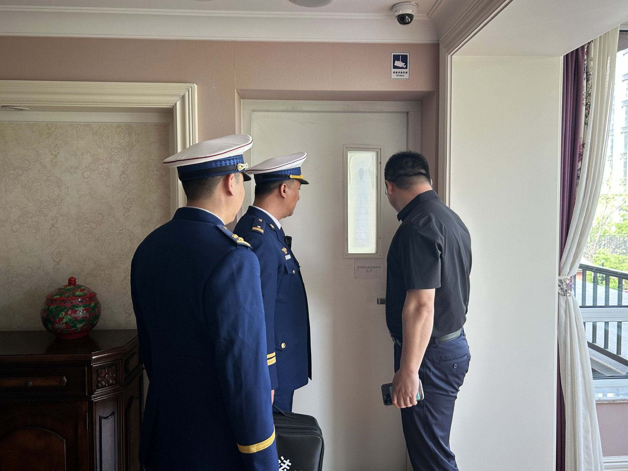 養老中心負責人向防火監督員展示,打開密碼門避難空間可與陽台相連。新京報記者彭鏡陶 攝