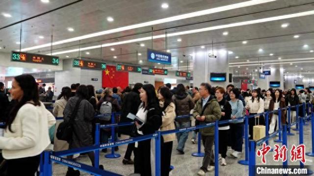 旅客有序排队候检,接受入境边防检查。(李宇航摄)