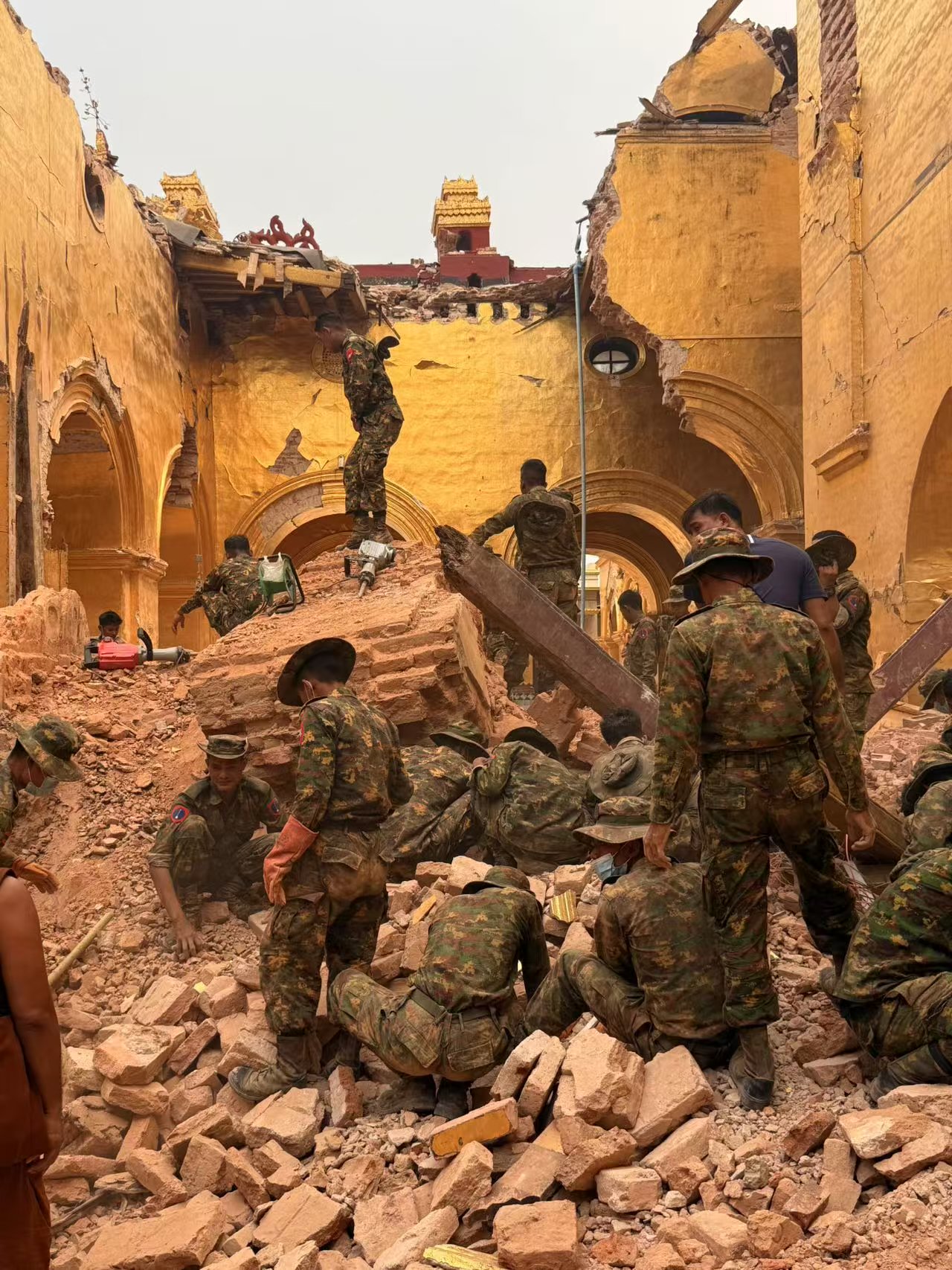 4月5日下午,曼德勒市馬哈穆尼寺主建築一走廊穹頂垮塌,當地軍人正在搬運塌毀的碎塊。新京報記者 叢之翔 攝