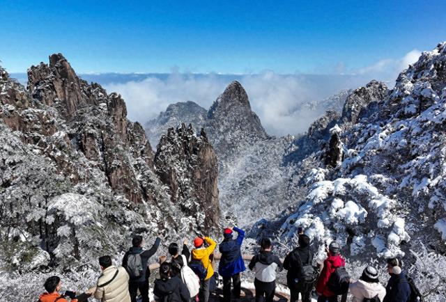 游客在安徽省黄山风景区欣赏春雪初霁的迷人景色。视觉中国 图