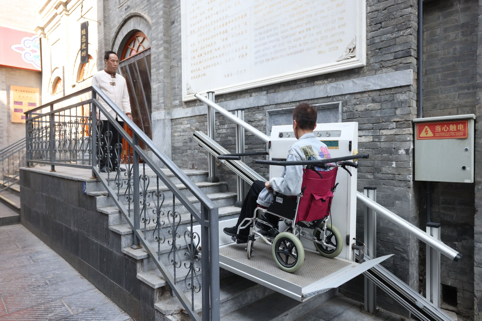 餐廳門前升降平台,工作人員正在演示升降平台使用。新京報記者 王貴彬 攝