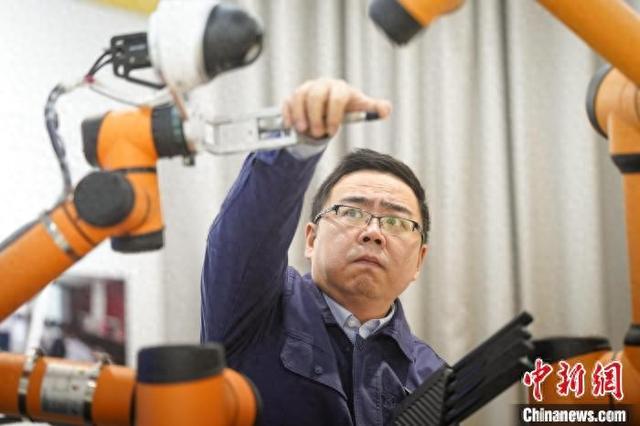 张霁明在调试5G智能巡检机器人。 国网浙江电力供图