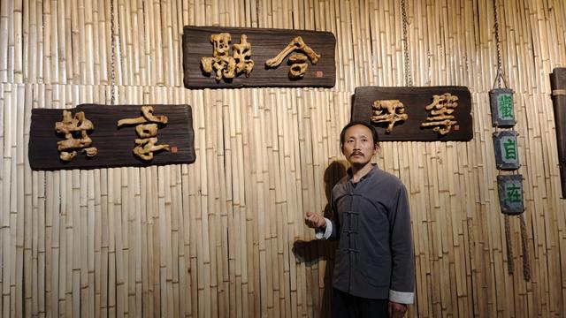 4月24日,李长庚介绍他创作的黄栌根艺书法。 澎湃新闻记者 王岱玉 图