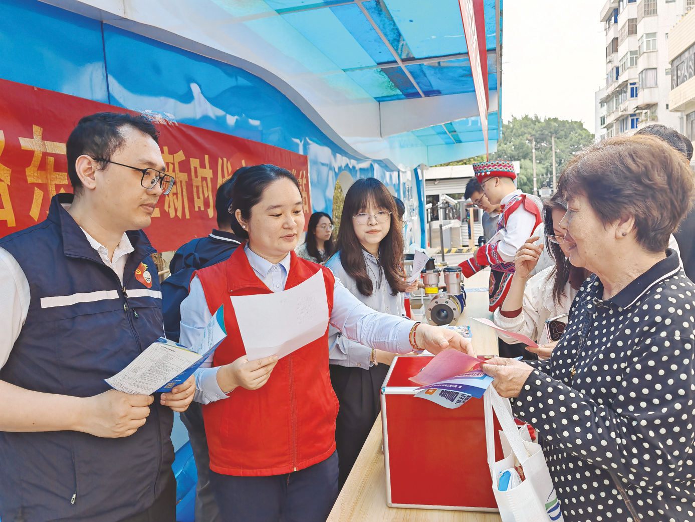     工作人员向居民发放节水护水宣传资料。    （马丽 摄）