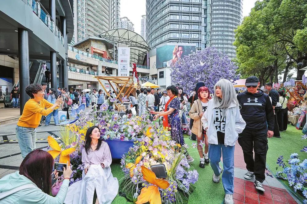 昆明顺城购物中心“蓝楹絮语·第二届花花市集”引来众多游客拍照打卡。胡妤雅 摄
