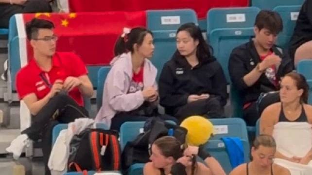 昌雅妮和陈芋汐在看台上热聊，旁边的郑九源凑近吃瓜，随后也加入聊天