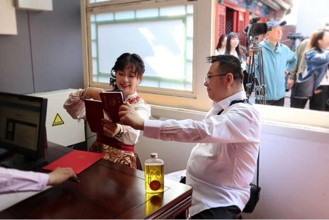 5月10日,在户外登记中心办理结婚证的新人拍照留念。杨丽/摄