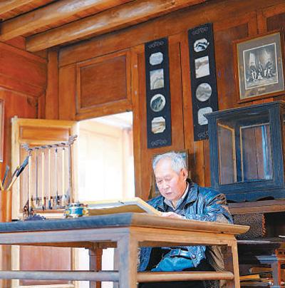 尹宪章在家中翻阅老照片。人民网记者 庄志斌摄