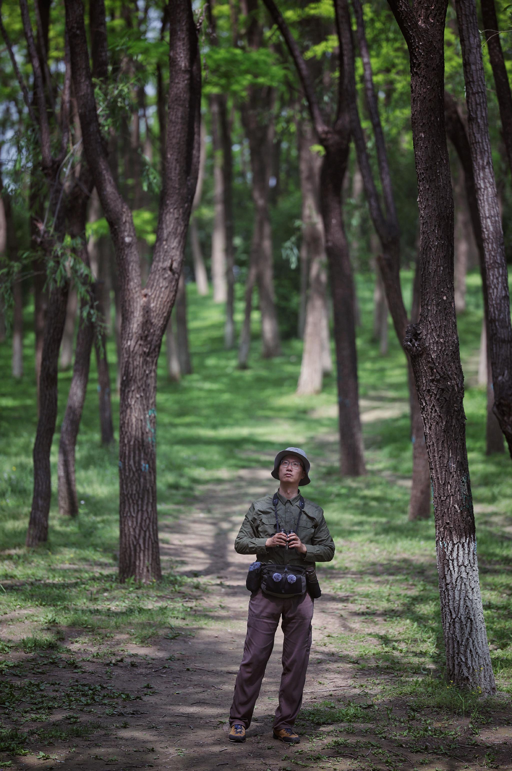 2025年5月12日,奧林匹克森林公園,李覺非在觀鳥。新京報記者 薛珺 攝