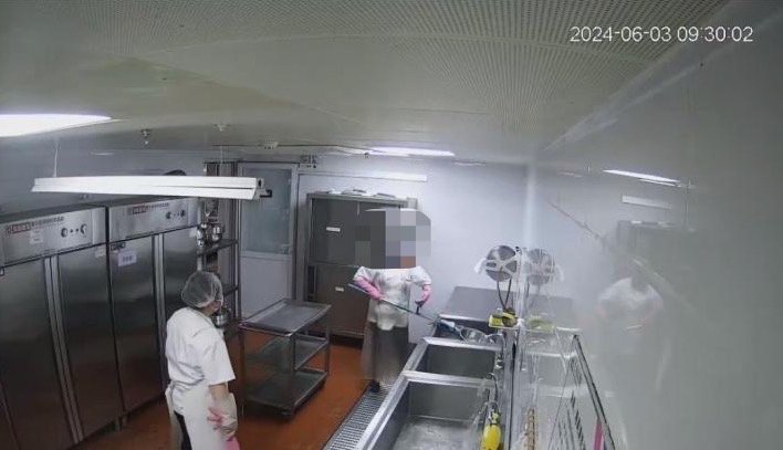 雷某在餐具池中洗墩布。圖源:石景山法院