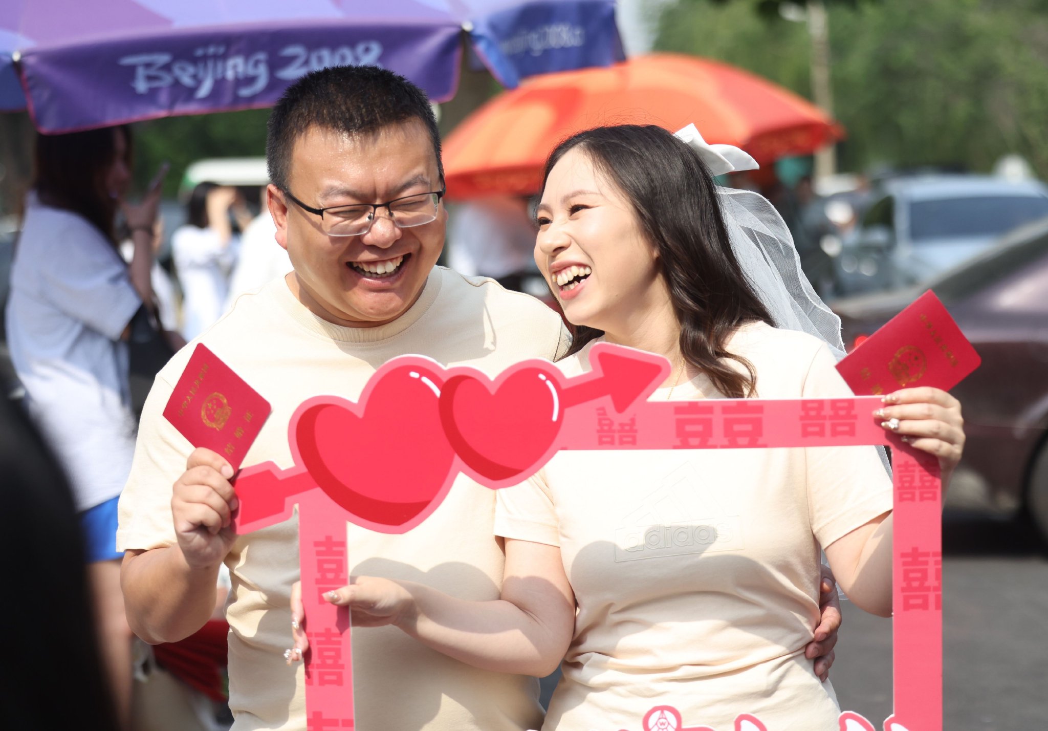 一對新人拿著結婚證開心地拍照。新京報記者 王貴彬 攝