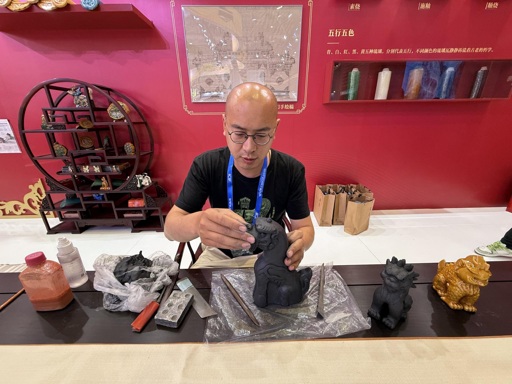 官式琉璃製作需歷經煉泥、塑形、素燒、釉燒等20餘道工序,展區工作人員製作官式琉璃。新京報記者 張建林 攝
