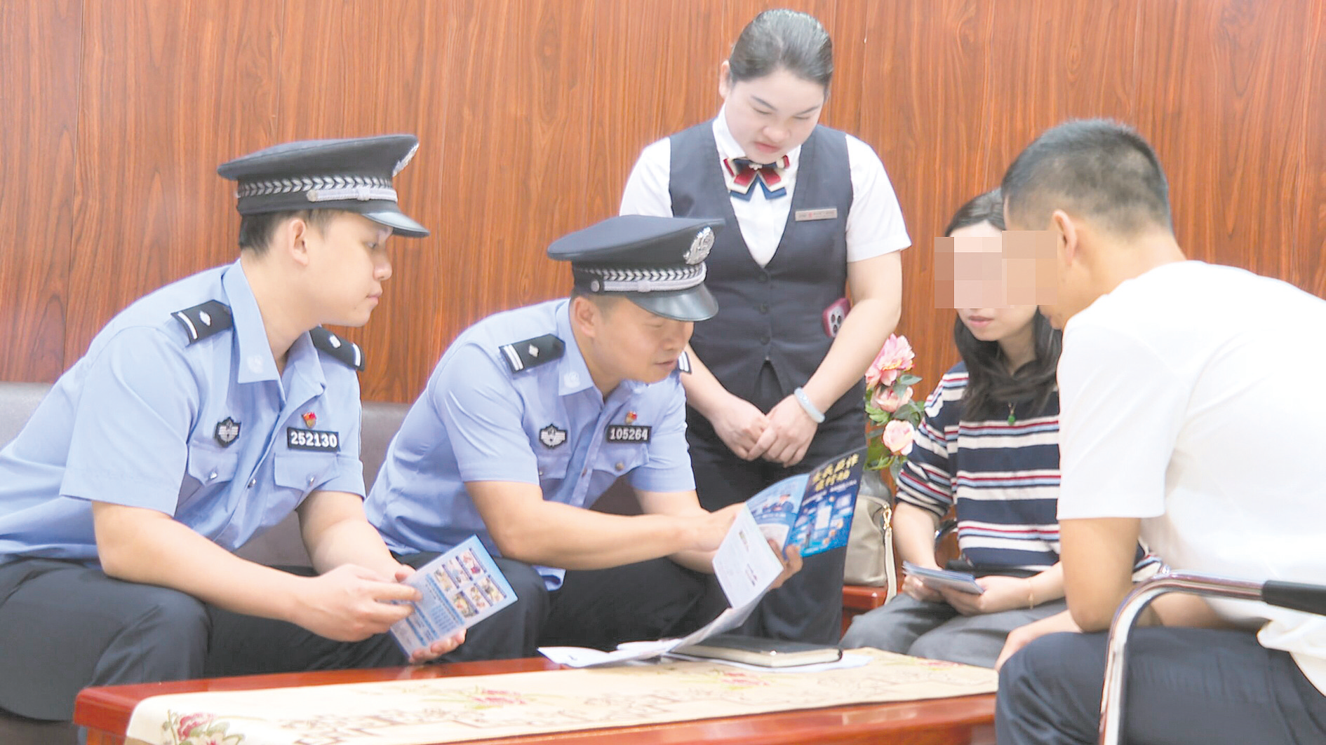     在银行网点，民警向险遭诈骗的市民宣传反诈知识。    （南宁警方供图）