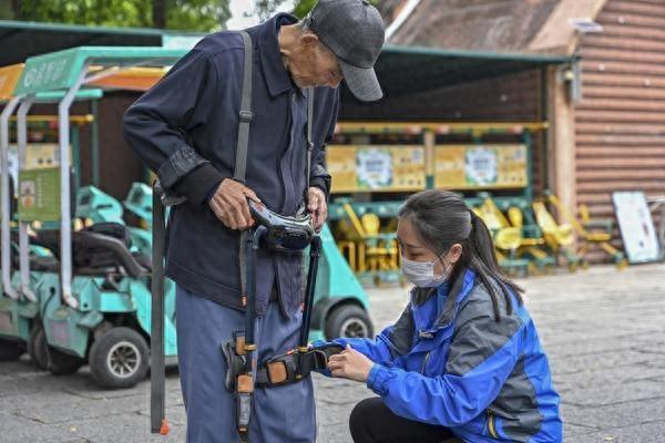 3月17日,广东深圳野生动物园工作人员帮游客穿戴外骨骼助力设备。视觉中国供图