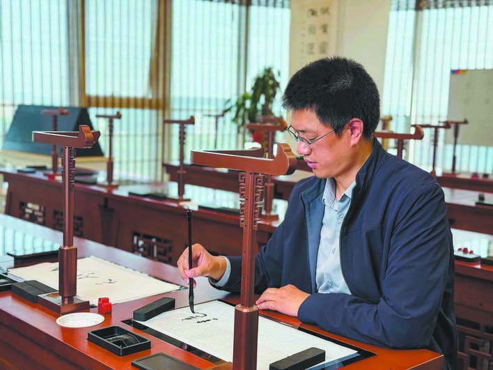 向大凤在第九代智慧书法教室临摹台上书写“绝壁天河”。(全媒体记者杜瑞芳 摄)