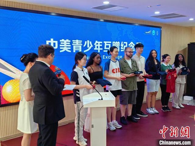 6月16日,“小球大爱”——纪念中美“乒乓外交”暨青少年乒乓交流活动在上海举行。图为中美青少年互赠纪念品。 范宇斌 摄
