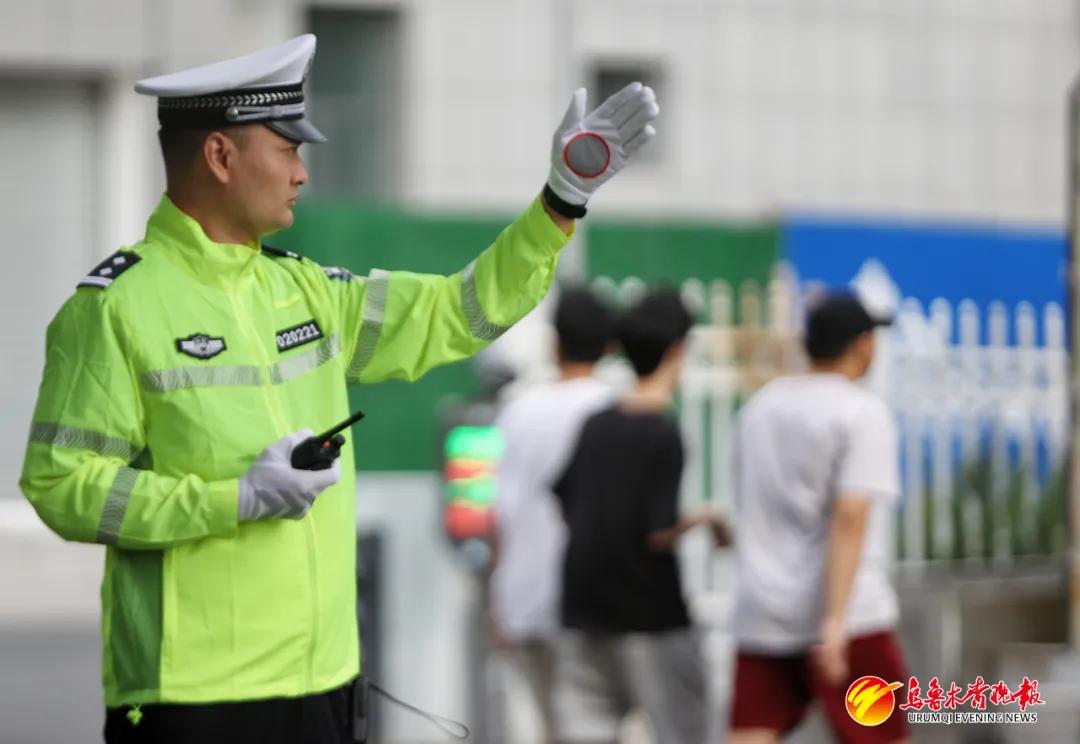 6月21日,在新疆农业大学附属中学考点,沙依巴克区交警大队民警在指挥考场周边交通。