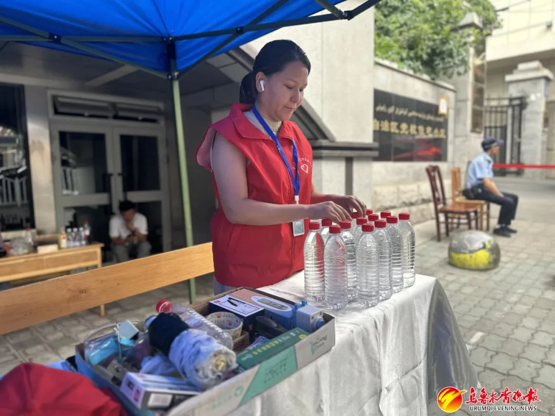在兵团二中校门口,志愿者正在摆放为考生和家长提供的矿泉水。