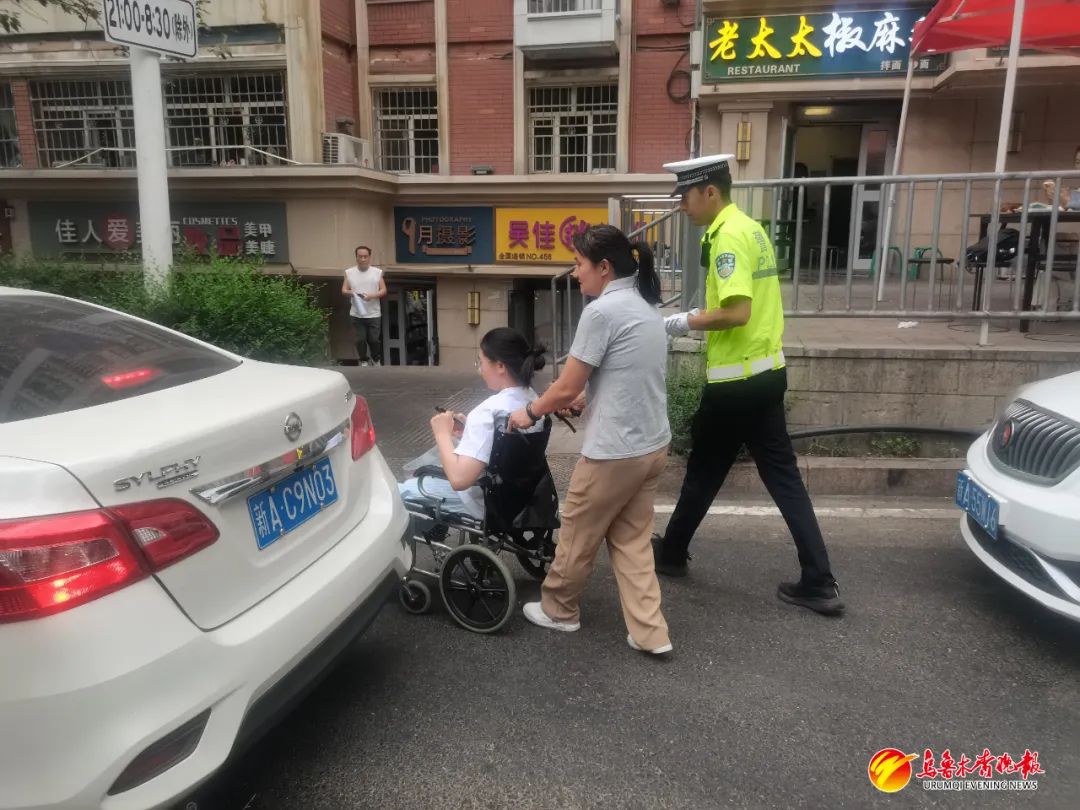 6月21日,在市第21中考点,水磨沟区交警大队民警余圣杰在护送先天残疾的特殊考生小琴(化名)。