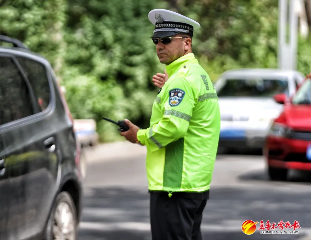 6月21日,在市第16中学考点,天山区交警大队民警卡哈尔·卡哈尔江指挥考场周边交通。