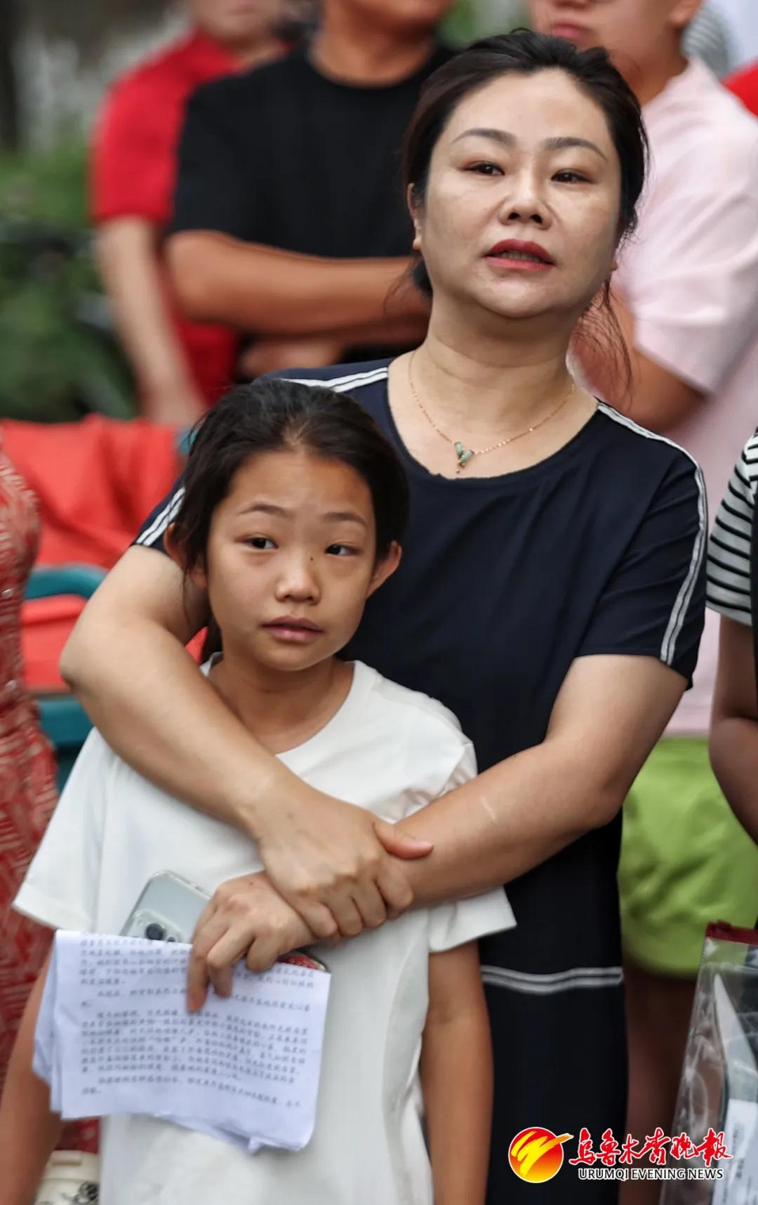 6月21日,在新疆农业大学附属中学考点,家长目送考生进考场。