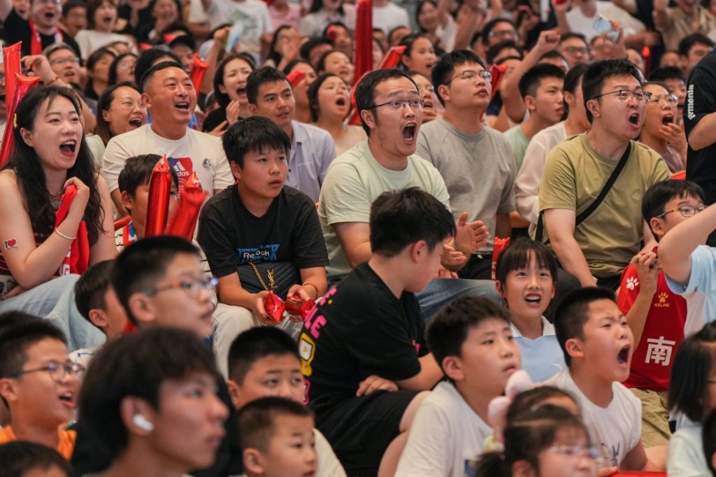 6月29日,市民、球迷在南通市内一处商场观看比赛直播,为球队加油呐喊。新华社 图