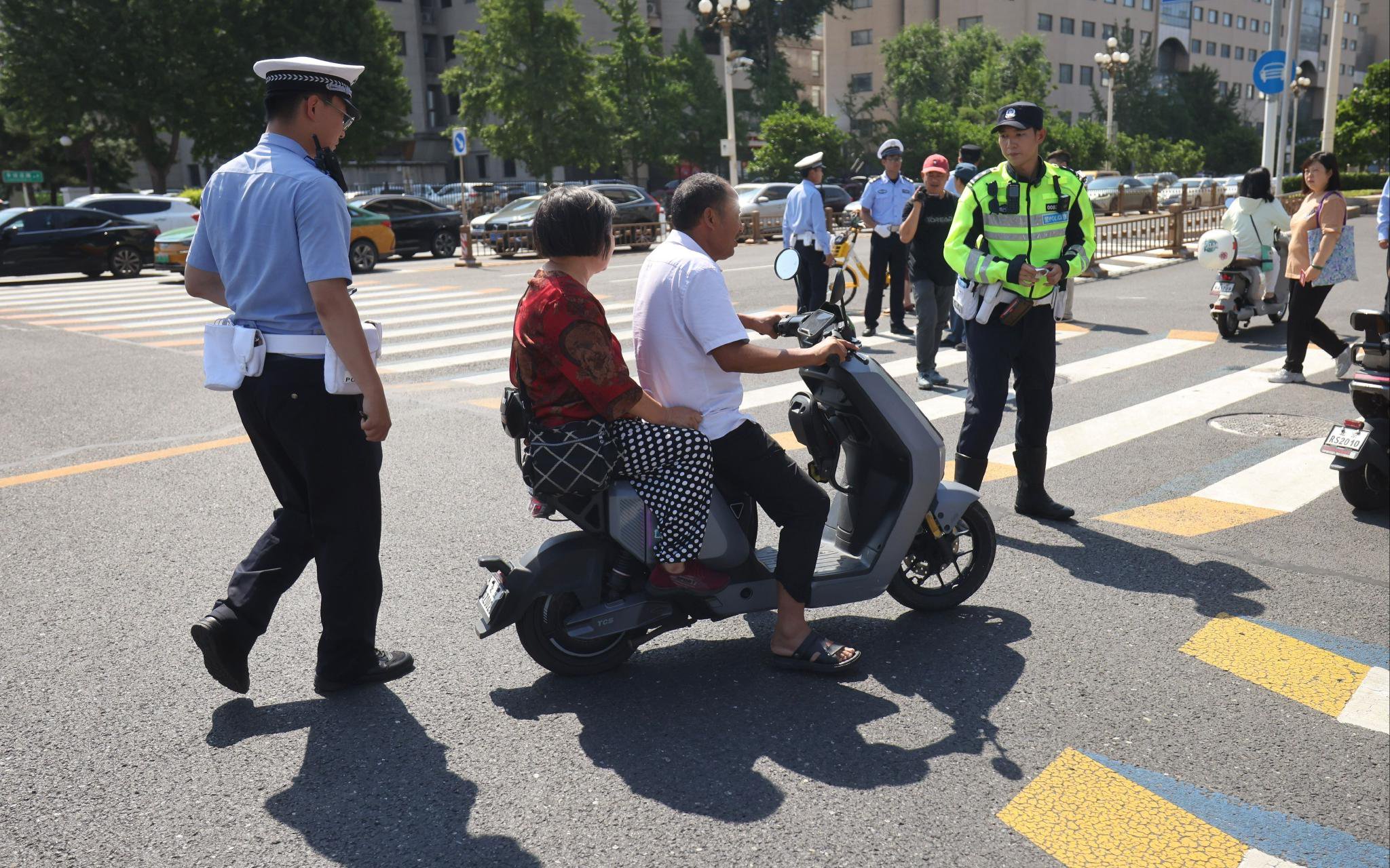 現場交警查處了多起電動單車違規帶人行為。新京報記者 王貴彬 攝