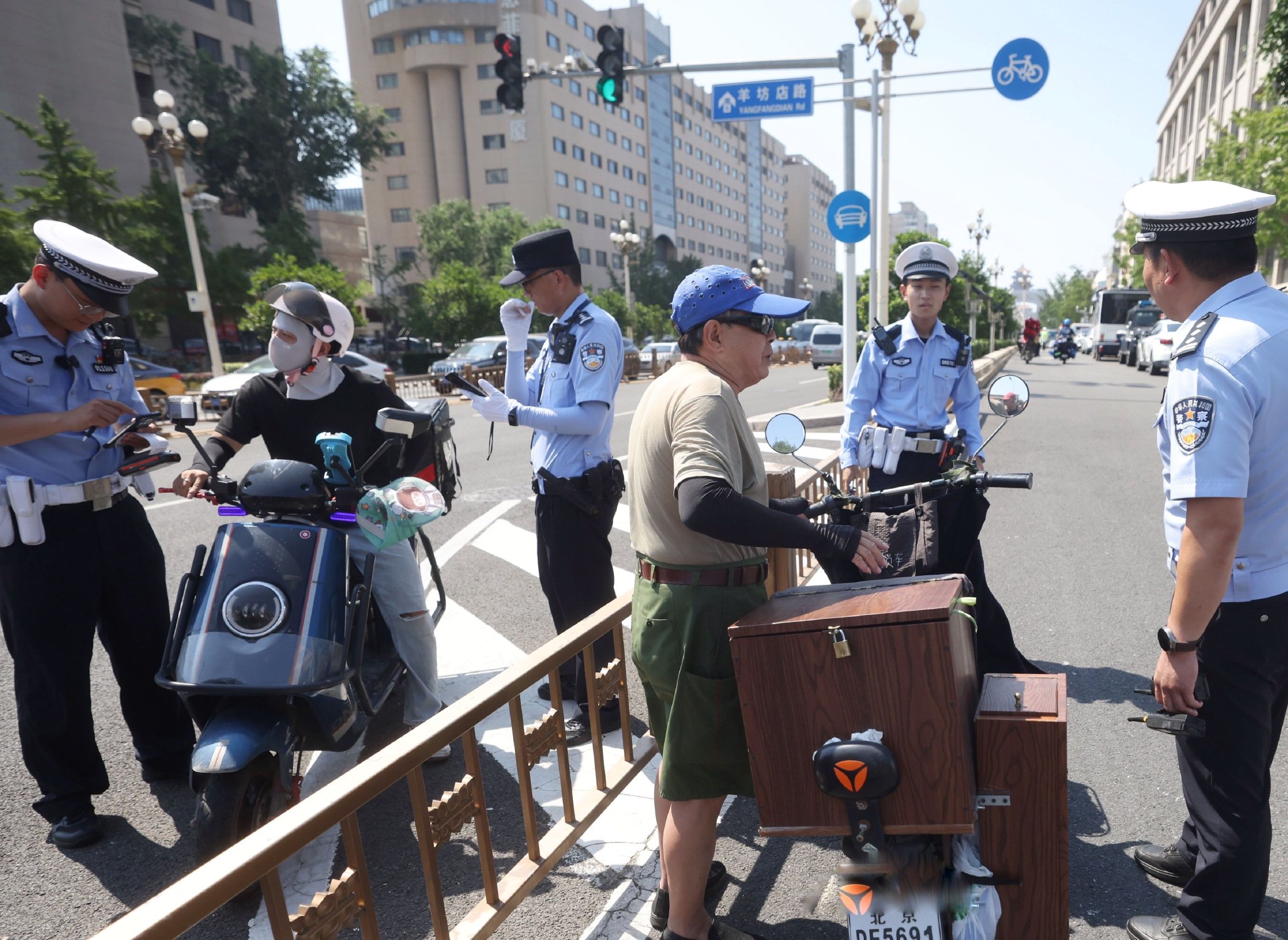 一輛逆行的電動單車和一輛違法改裝的電動單車被交警攔下進行處罰。新京報記者 王貴彬 攝