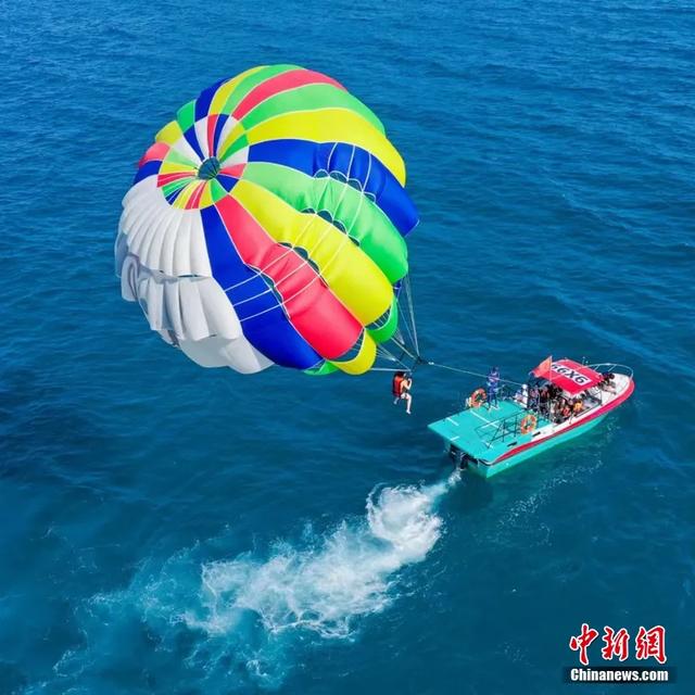 在万宁加井岛体验海上拖伞!随着快艇加速升空,感受海风拂面的自由与心跳加速的畅快。寰球拓海供图