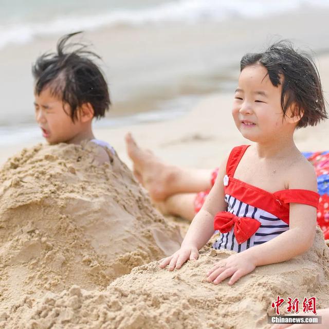 在三亚大东海,用沙子轻轻覆盖身体,享受天然“Spa”。骆云飞 摄