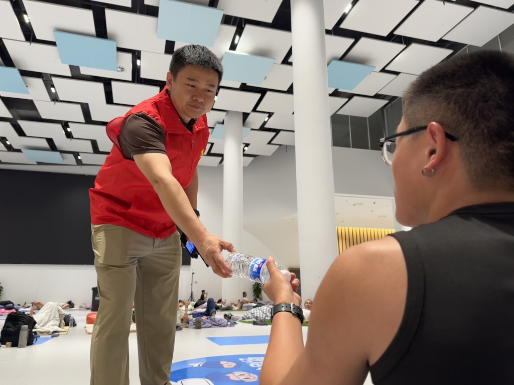 7月29日,临港少年宫,焦敏正在分发纯净水。 受访者 供图
