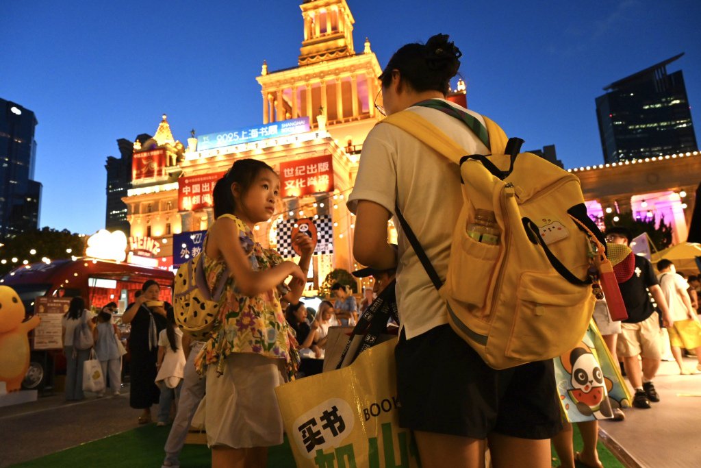 8月13日晚,吴女士带着女儿在上海展览中心逛书展夜市。澎湃新闻记者 吴栋 图