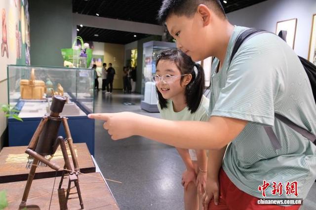 8月3日,孩童在竹制工艺品前驻足细看。曹丹 摄