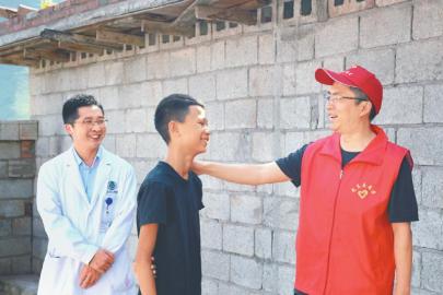 在普格县西洛镇博基村,帮扶干部陈炼(右)与援彝医疗专家邓刚(左)上门为村民阿洛成兵做康复检查。