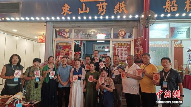 9月12日,海外华媒一行人来到福建东山参访,图为体验东山剪纸并合影留念。廖珍妹 摄