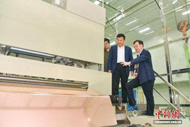 图为廖平元(右)向南开大学陈军院士(中)介绍铜箔生产情况。受访者供图