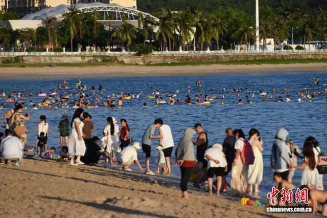 10月3日,国庆假期第三天,海南三亚大东海旅游区吸引中外游客在碧海蓝天间乐享惬意假期。中新社记者 骆云飞 摄