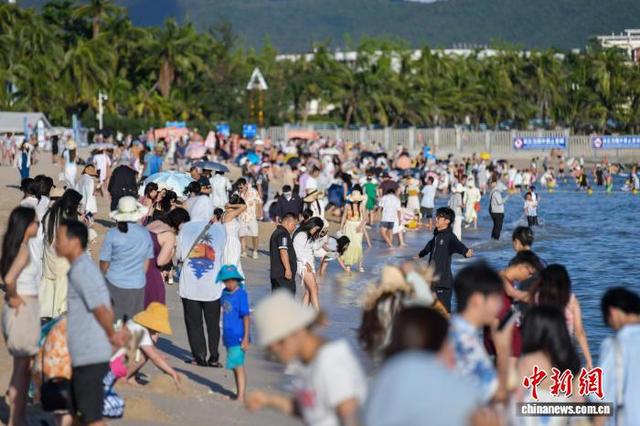图为中外游客在三亚大东海旅游区游玩。中新社记者 骆云飞 摄