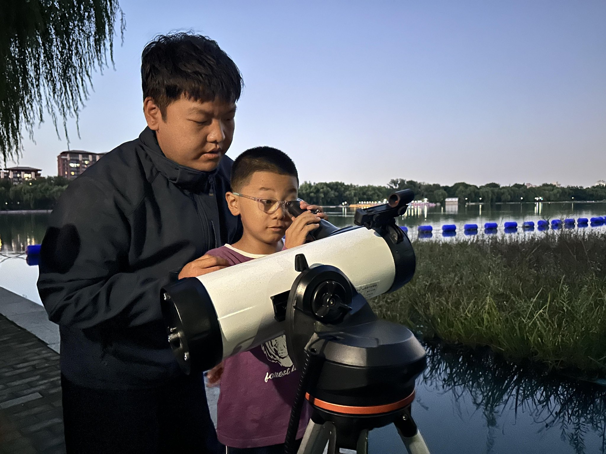 遊客用天文望遠鏡觀賞月亮。玉淵潭公園供圖