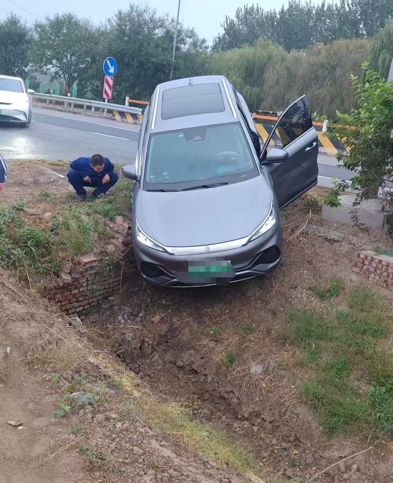 消防員查看王女士被卡在排水溝的車輛。大興消防供圖