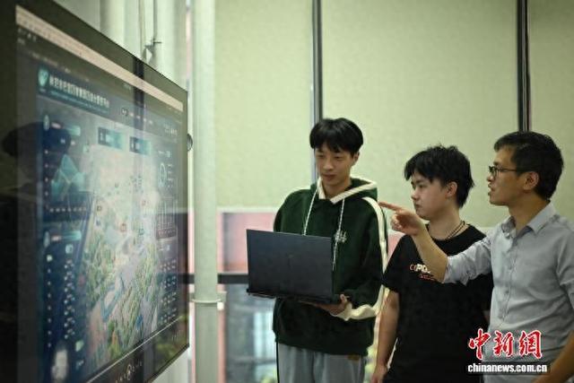 图为陈松鑫(右一)和同事在讨论工作。张旭 摄
