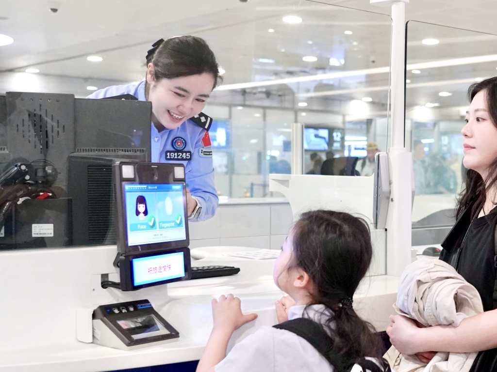 移民管理警察为旅客办理出境边检手续。李宇航 摄