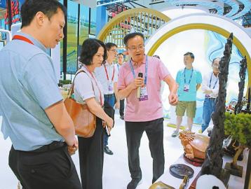 程学勇（中）在南博会上为各地客商介绍产品。