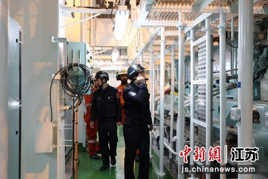 移民管理警察对“绿能星”轮进行船体检查。李俊 摄