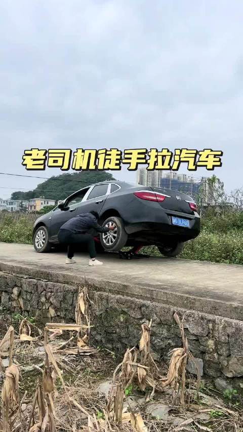 汽车一侧掉下路坎老司机徒手拉汽车