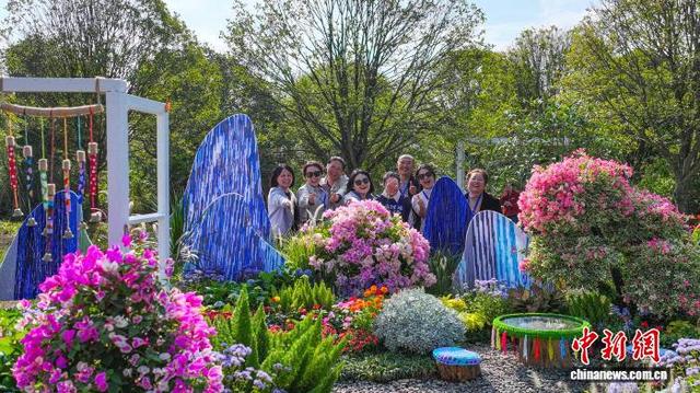 图为第四届南方花卉苗木交易会，民众在户外花卉造型景观前合影。杨宗盛 摄