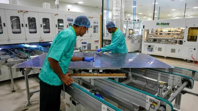 在印度斋浦尔郊区的一家制造工厂，工人们正在检查太阳能电池板。 图源：美联社
