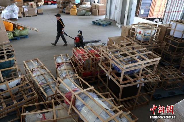 图为一家物流企业工作人员准备使用拖车搬运大型瓷瓶。中新社记者 刘占昆 摄