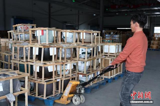 图为现场一家物流企业工作人员正在搬运陶瓷水缸。中新社记者 刘占昆 摄